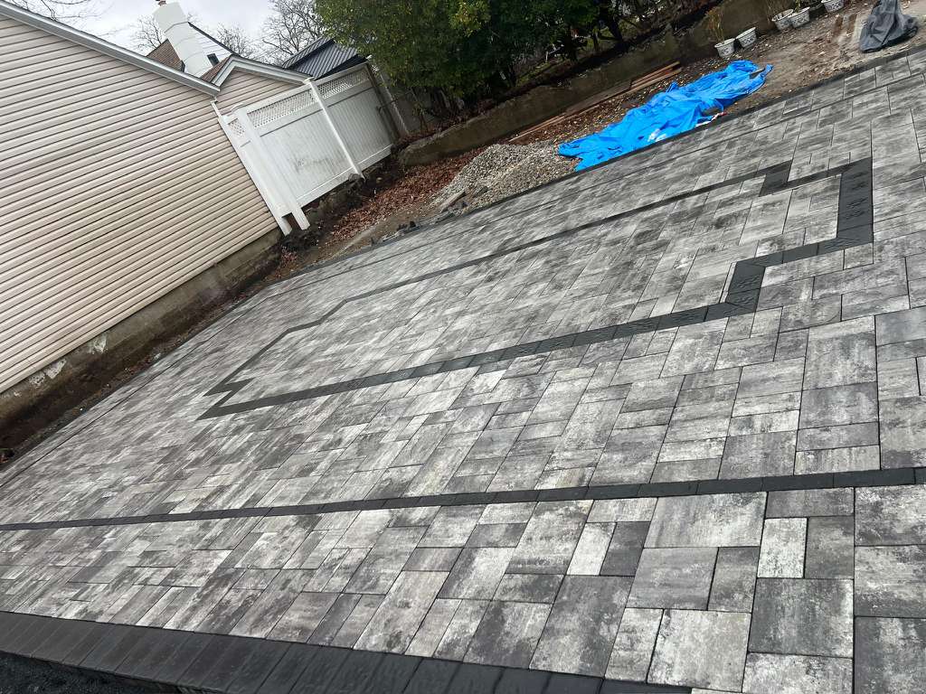 backyard and driveway pavers installation project in floral park ny with custom brick and stone design